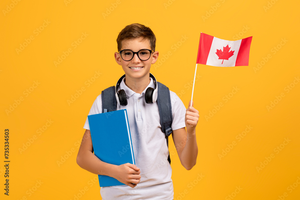 International Education. Happy Teen Boy With Backpack Holding Canadian Flag And Workbooks International Education. Happy Teen Boy With Backpack Holding Canadian Flag And Workbooks