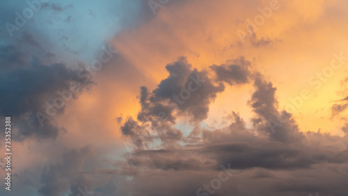 Cloudy orange sky sunset with clouds before the sun sets..Beautiful vibrant textures of the sunset sky and rain clouds.