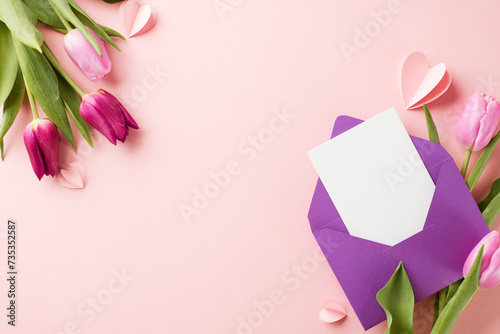 Elegance and affection: celebrating the heart of the mother. Top view of a bouquet of fresh tulips, purple envelope, card, tender hearts on pastel pink background with space for greetings or promo