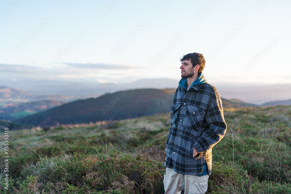 A young man walking through the countryside looking at the landscape A young man walking through the countryside looking at the landscape