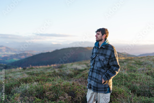 A young man walking through the countryside looking at the landscape