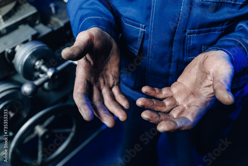 Working men with dirty hands stay near milling machine. Concept hard work of industry photo