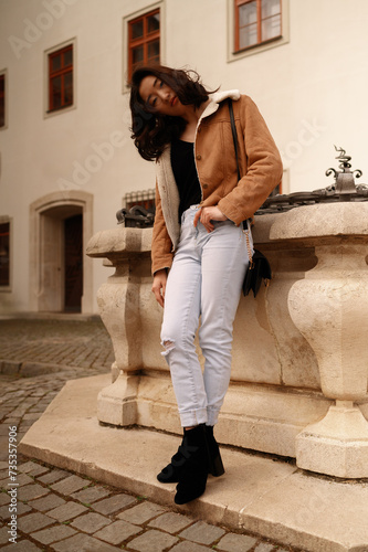 Graceful Young Woman Enjoying a Serene Moment on Cobblestone Streets by Historic European Architecture.
