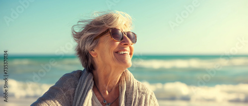 Retrato de uma mulher sênior feliz na praia ao pôr do sol no verão