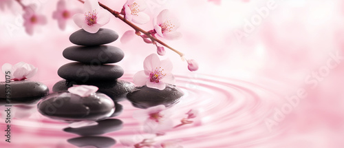 pedras de basalto zen e flor de sakura no fundo da água photo
