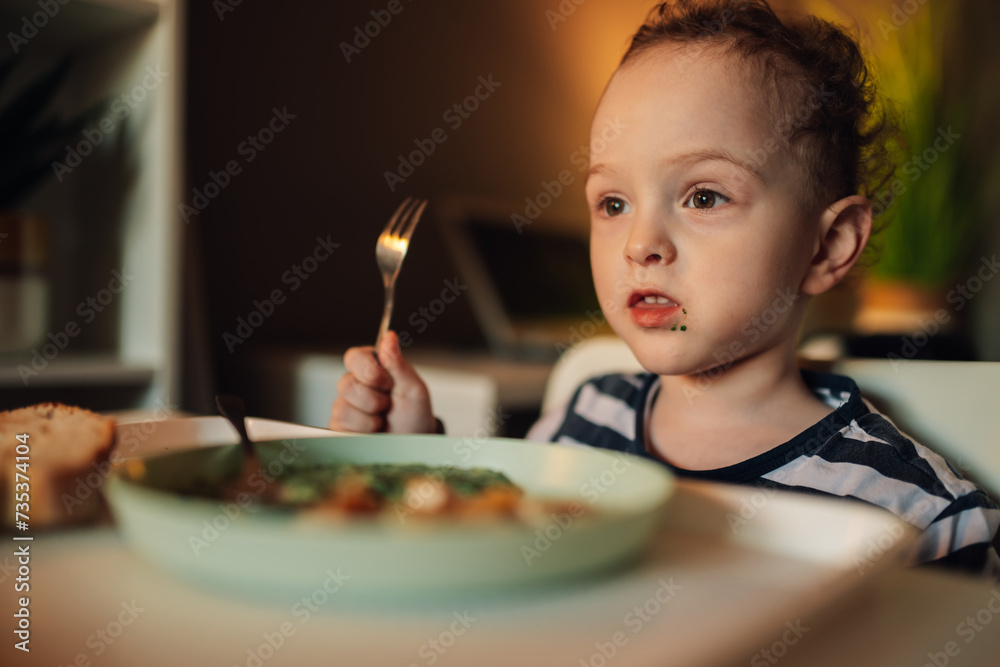 Close up of a hungry child at dining table eating his lunch. Close up of a hungry child at dining table eating his lunch.