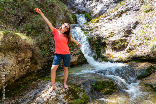 Hiker woman next to idyllic river Foelzbach  Hochschwab mountains  Styria  Austria. Hiking trail in alpine forest. Remote Austrian Alps in summer. Sense of escapism  reflection. Connect with nature
