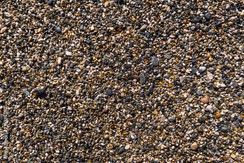 Close up of a Sea Shore Beach, Pebbles, Sand and Rocks Texture Abstract Background