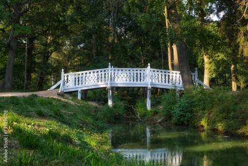 A white wooden bridge over a stream photo