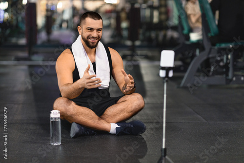 Blogging Concept. Smiling Muscular Man Recording Video Content At Gym