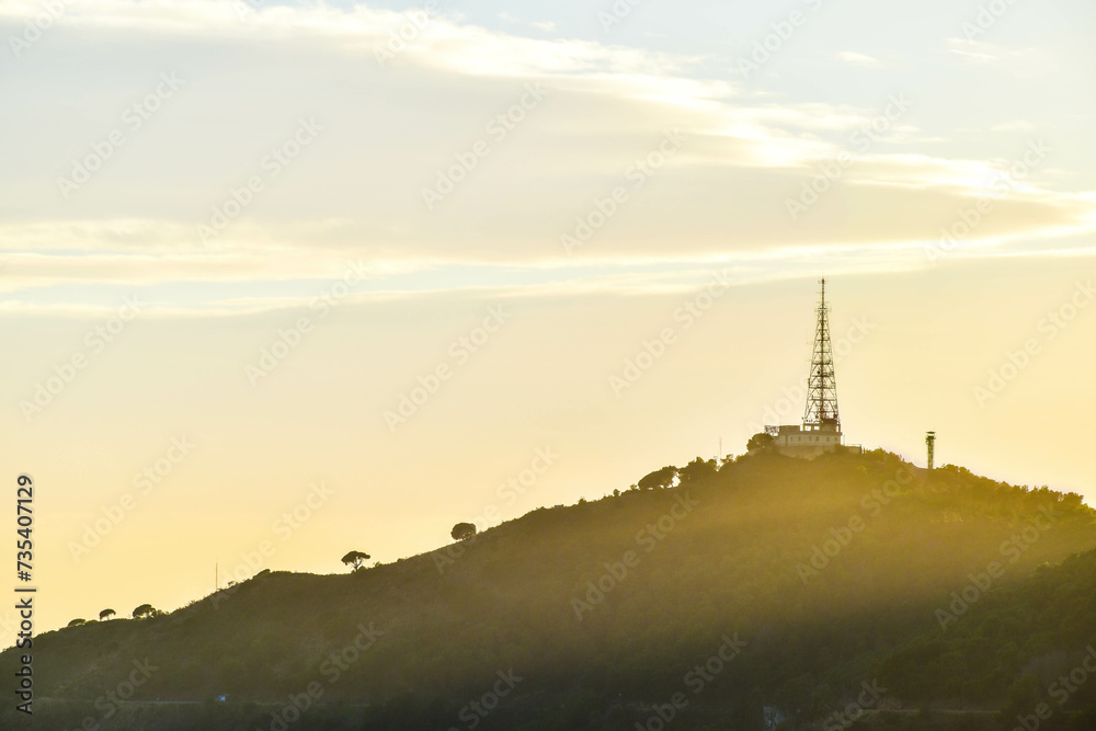 Telecommunications tower on top of a mountain during sunset