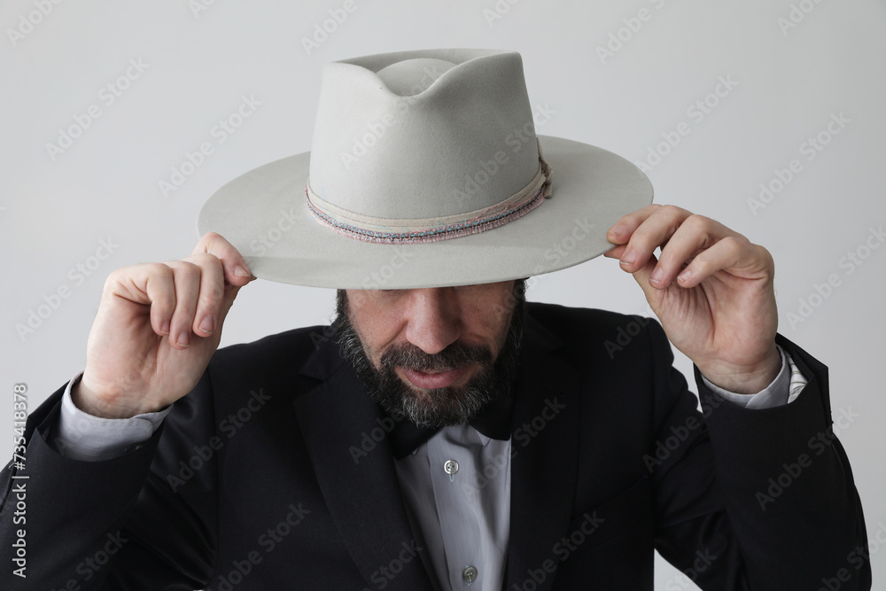 Portrait of man wearing gray hat looking away and poses at the studio. Isolated. Portrait of man wearing gray hat looking away and poses at the studio. Isolated.