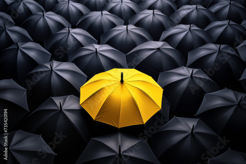 Yellow umbrella in a crowd of black one