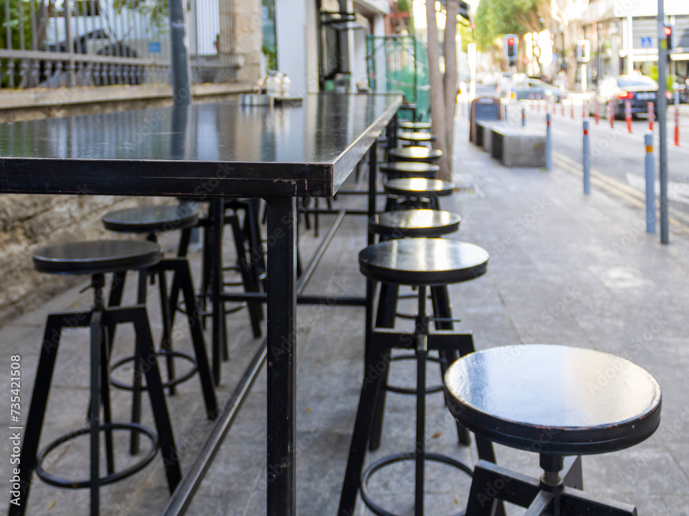 Empty table and bar stools at city street, Limassol, Cyprus 