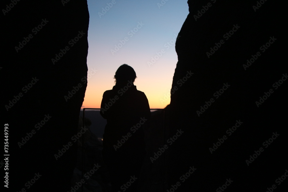 silhouette of woman watching sunset in the mountain.