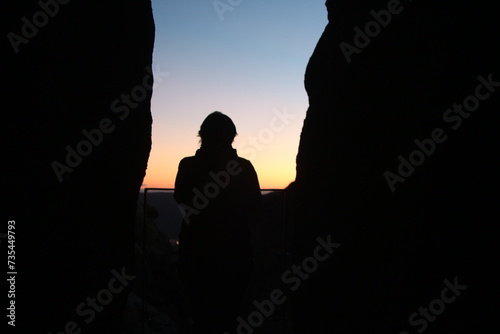 silhouette of woman watching sunset in the mountain.