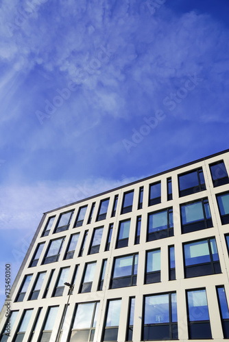 Look up to white building facade towards blue sky. Kopli, Tallinn, Estonia. February 2024