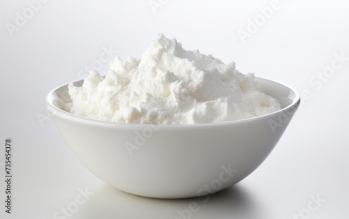 Cottage cheese in a white bowl on a white background, close-up