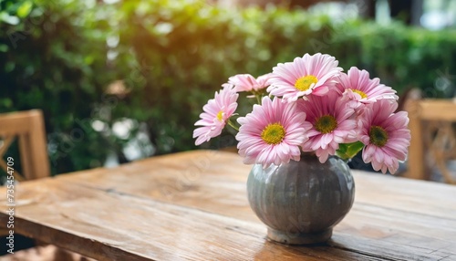 fresh pink daisy blossoming flowers in vase on wooden table decorations in cafe
