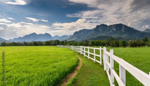 green pastures with white cement fence