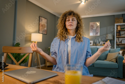 one woman adult caucasian work on her laptop at home meditation relax photo