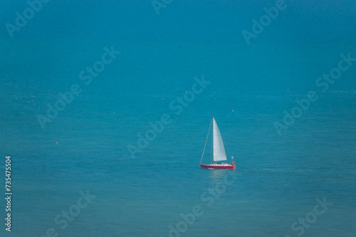Sailboat sails gracefully across turquoise blue off the coast of South England