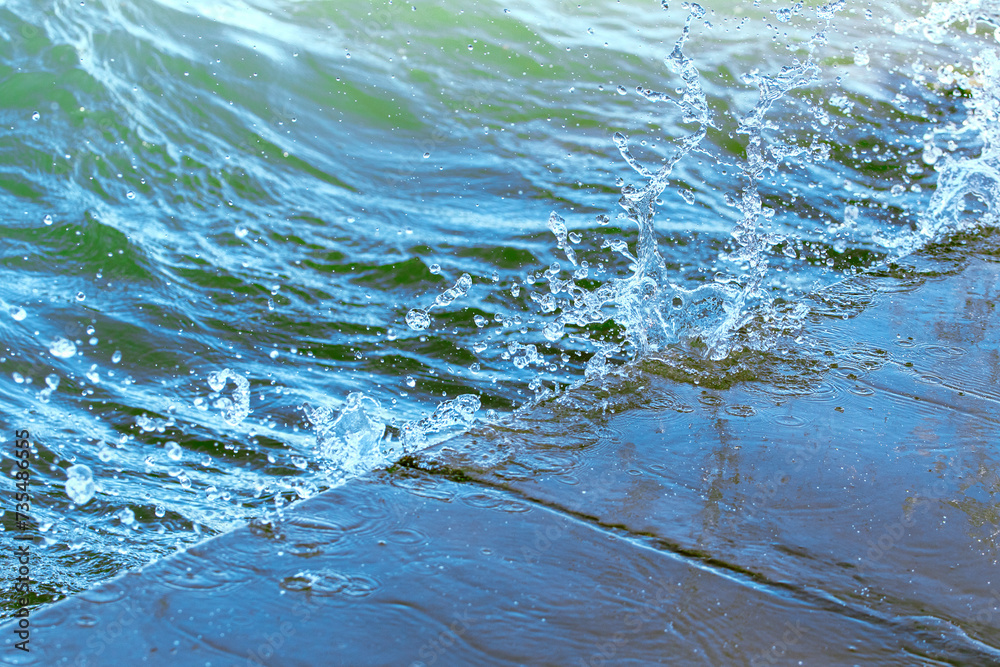 Splash in the water, water droplets, abstract blue background