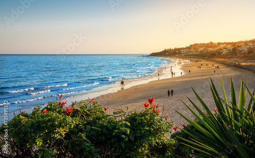 Costa Calma beach in the sunset light with people enjoying the summer vacation on the Atlantic Ocean coast in Fuerteventura Island in Canaries