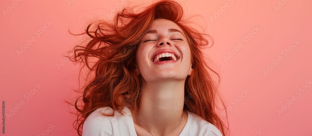 Beautiful young woman with vibrant red hair wearing a stylish white shirt in a natural pose