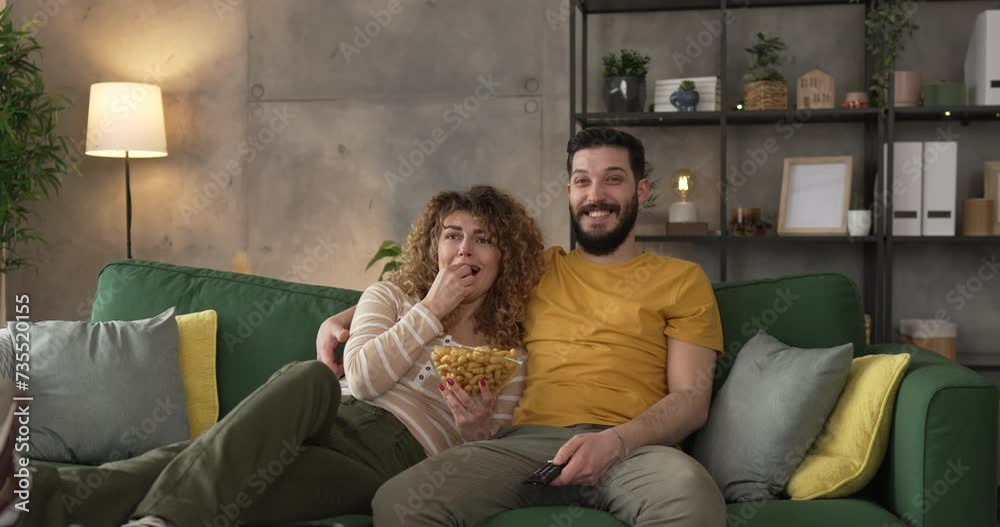 Couple caucasian man and woman sit at home on sofa bed watch tv movie