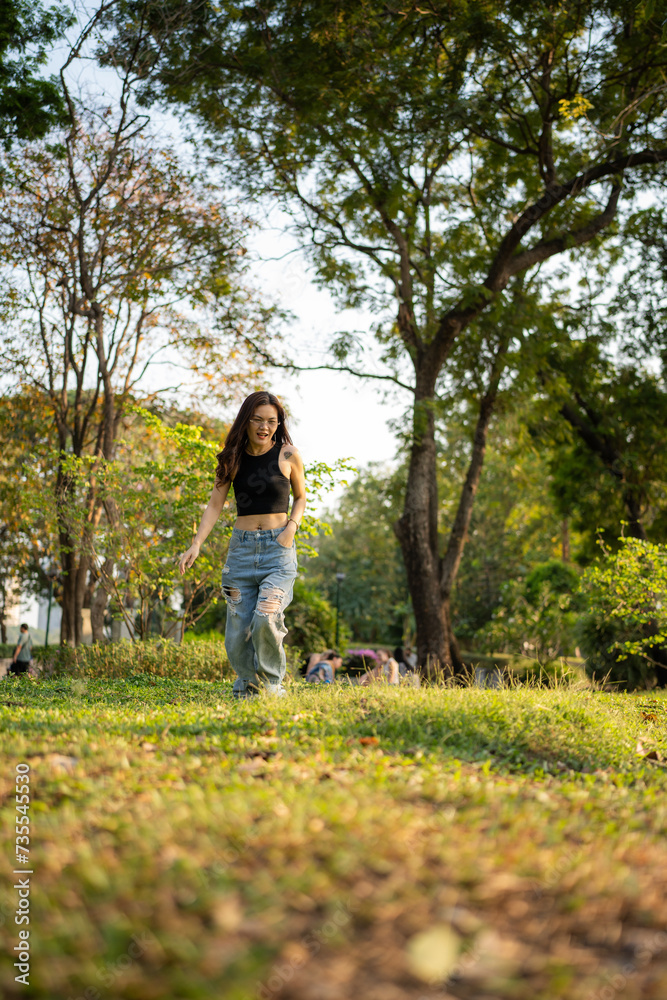 Naklejka premium Portrait of asian woman relax in city park sunset light sky