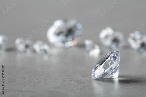 Beautiful shiny diamond on gray table  space for text
