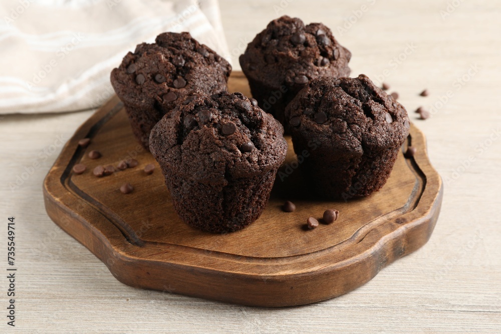 Delicious chocolate muffins on white wooden table Delicious chocolate muffins on white wooden table