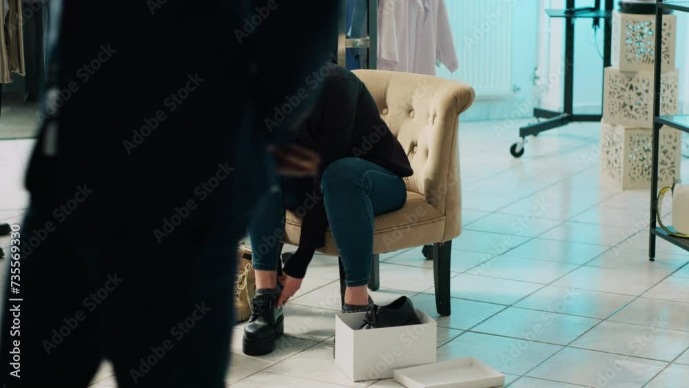Trendy customer trying on elegant shoes with laces at fashion boutique, looking to buy new footwear for an office style outfit. Woman on shopping spree at department store. Camera A.