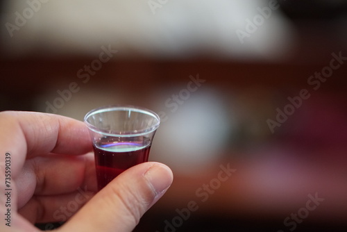 Hand holding wine in a Holy communion.