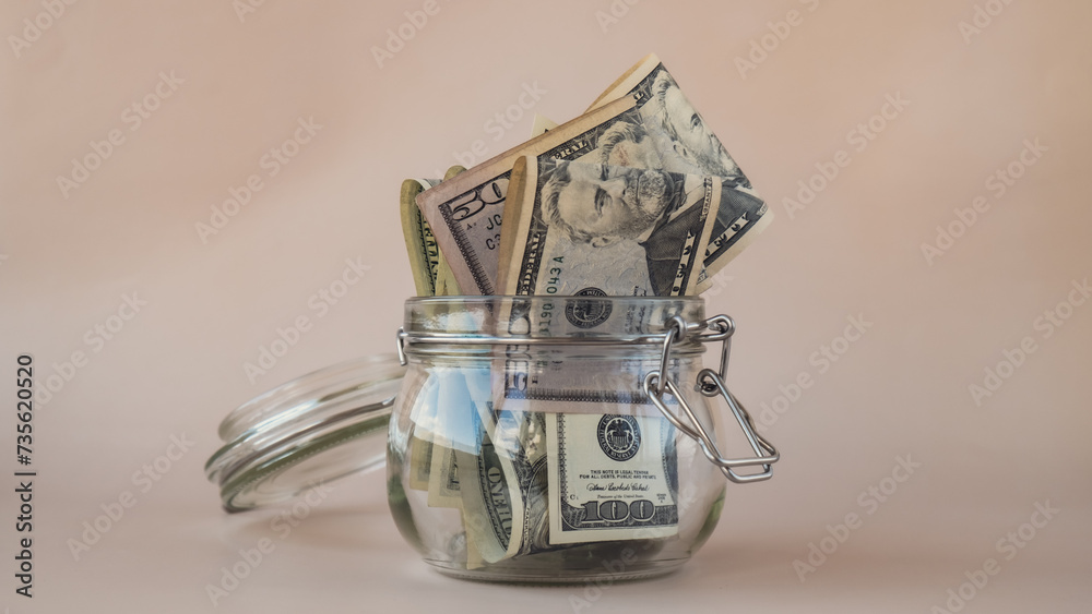 Dollar banknote saving money in glass jar on beige background. Consumption and economy Collecting money. Tips. Extra money, passive