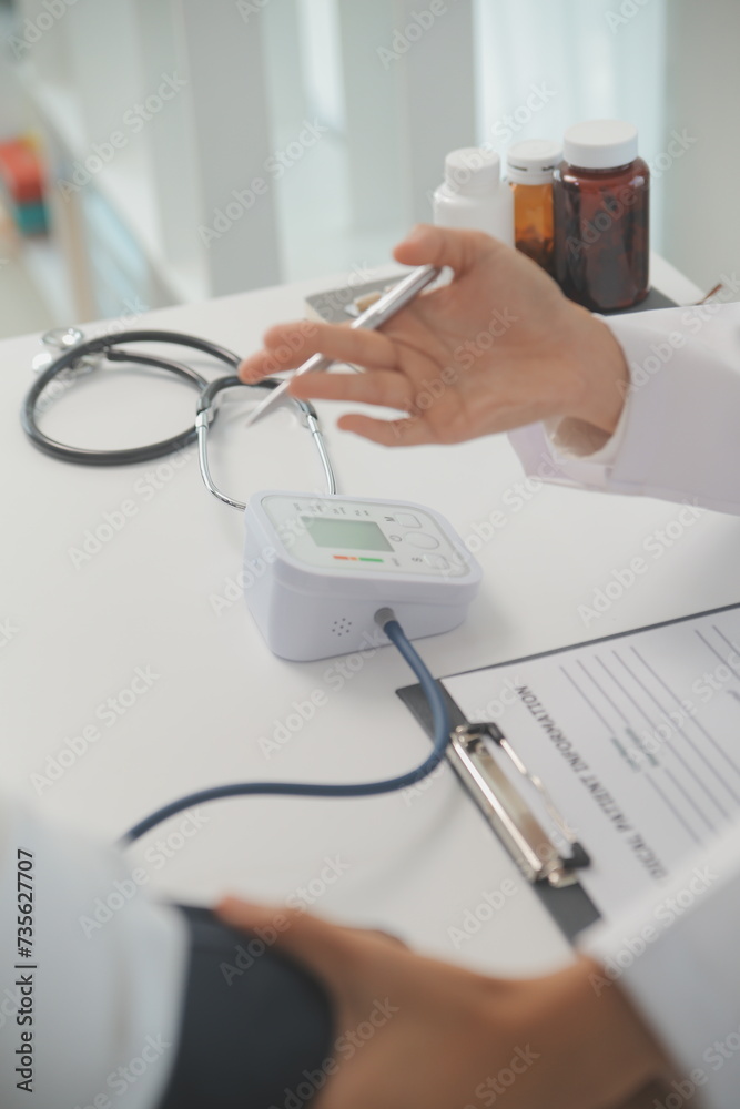 Male doctor uses a blood pressure monitor to check the body pressure and pulse of the patients who come to the hospital for check-ups, Medical treatment and health care concept. Male doctor uses a blood pressure monitor to check the body pressure and pulse of the patients who come to the hospital for check-ups, Medical treatment and health care concept.