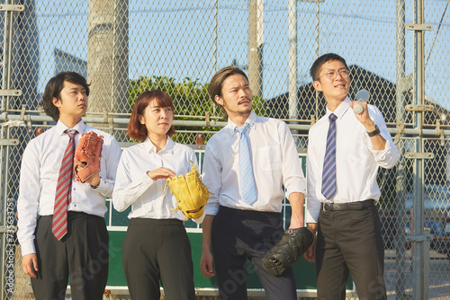 野球道具を持って並ぶ4人のスーツを着た男女 photo