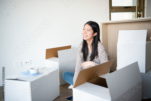 引越しの段ボールに囲まれて笑っている女性 photo