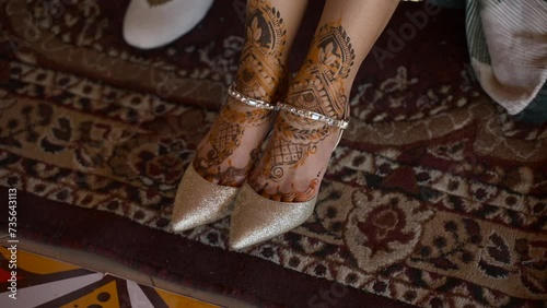 Close up of bride in wedding shoes, henna drying on Indian bride. HD footage. photo