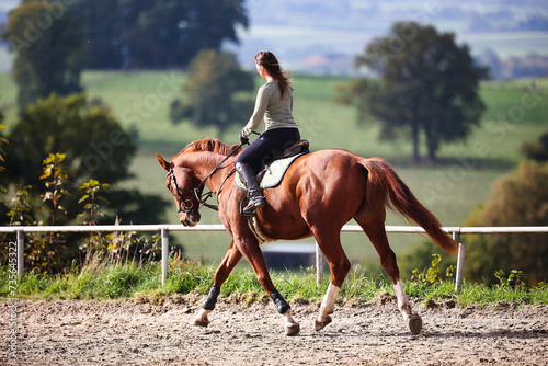 Horse woman rider riding in the sunshine at the riding arena. photo