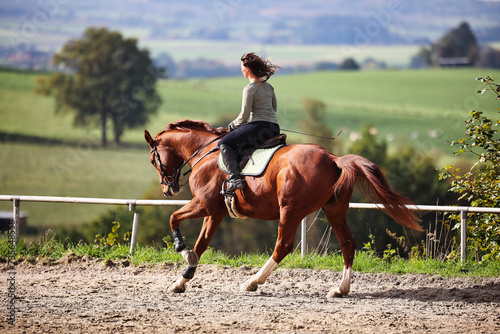 Horse woman rider riding in the sunshine at the riding arena. photo