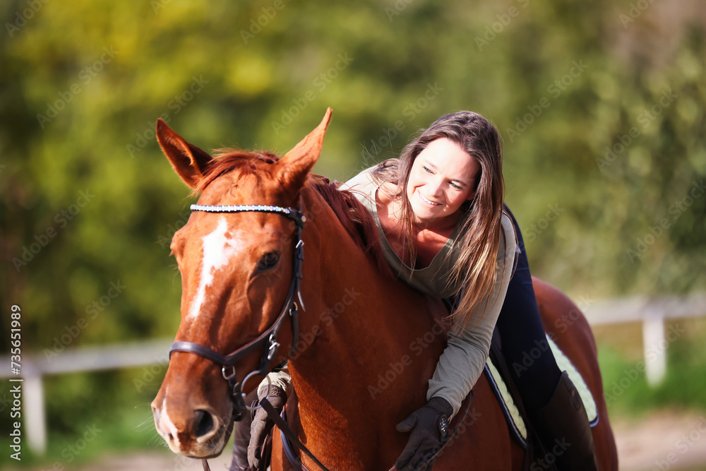 Obraz premium Horse woman rider riding in the sunshine at the riding arena.