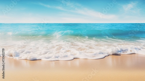 Soft waves of the sea on a sandy beach with blue sky.
