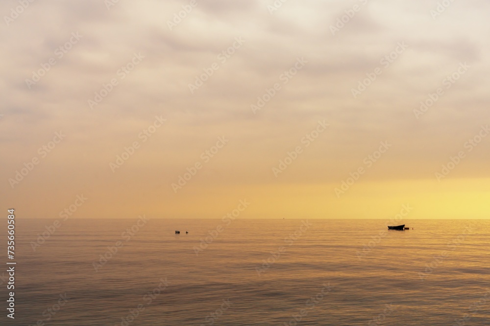 small boat at nachor in a calm ocean at sunset