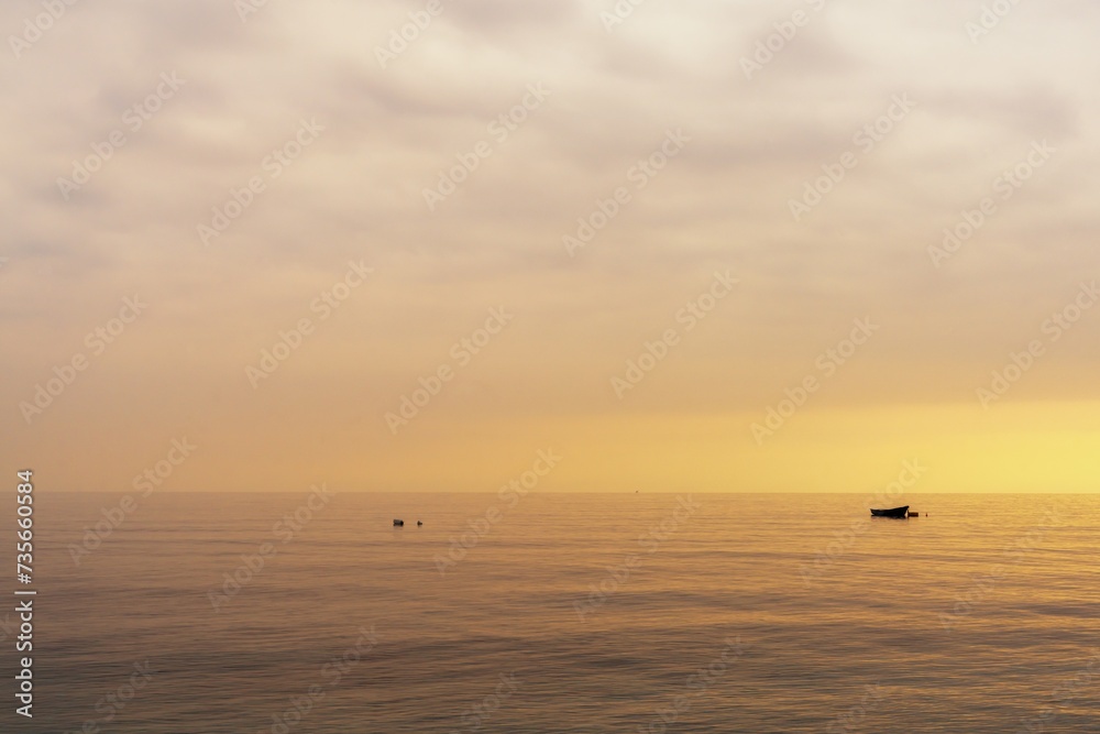 small boat at nachor in a calm ocean at sunset small boat at nachor in a calm ocean at sunset