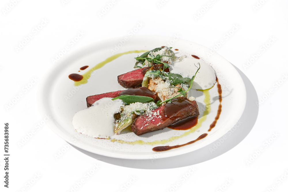 Pan-seared veal cutlet with cheese espuma and Demi-glace sauce on a sophisticated white plate for a refined culinary presentation