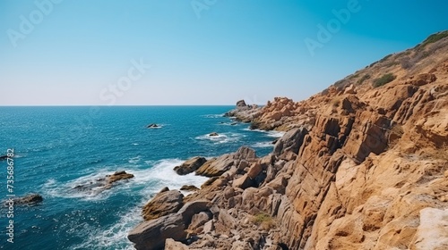 Rocky monumental steep coast near the blue ocean without vegetation empty stone and deserted bright sunny day heat