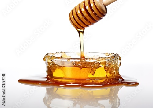 honey dripping from honey spoon in glass bowl