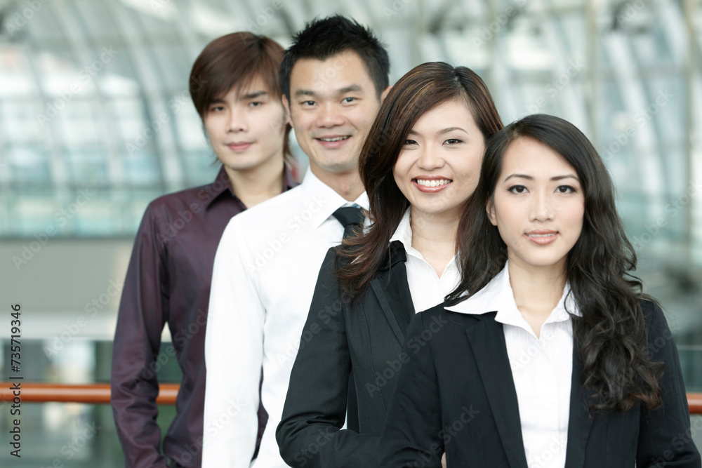 Obraz premium Asian Business colleagues standing in a row and smiling